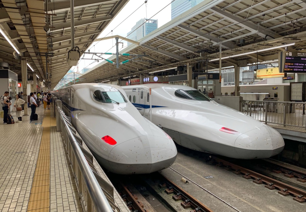 A high-speed Shinkansen bullet train traveling through the Japanese countryside