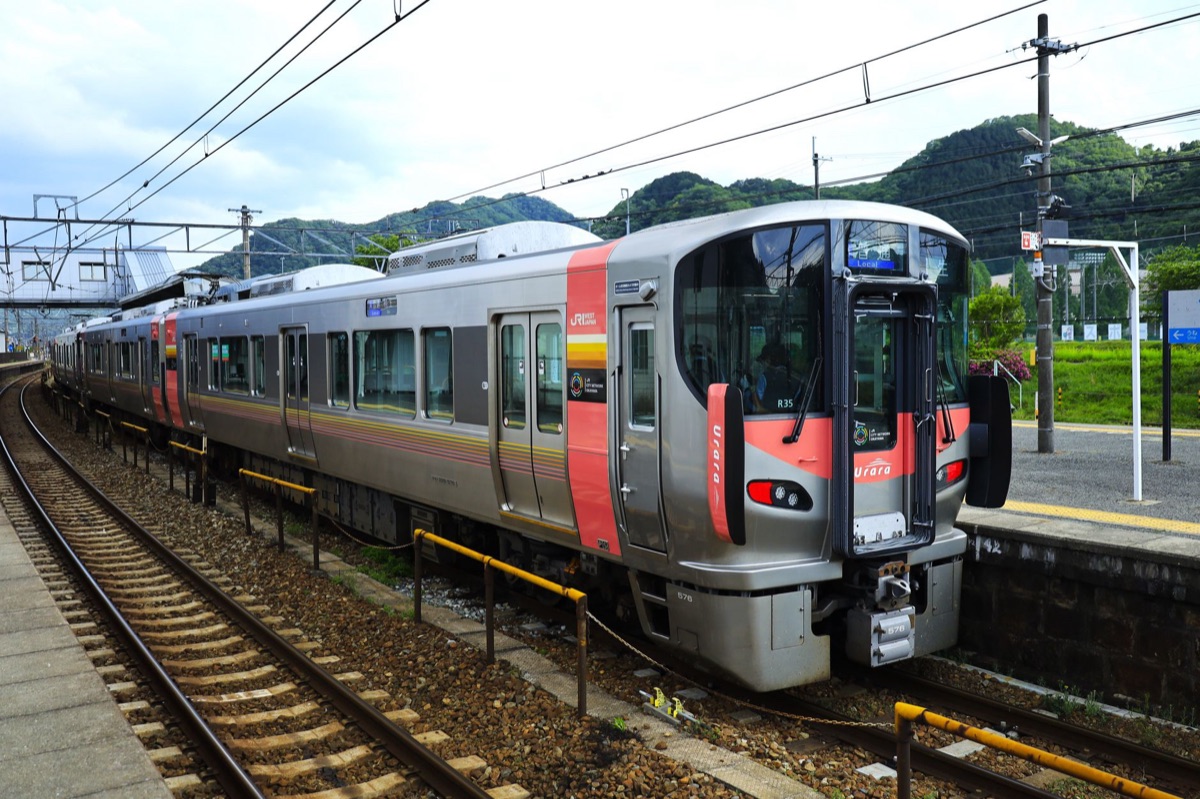 Vue par la fenêtre d'un train JR : l'intérieur d'un compartiment à l'arrêt