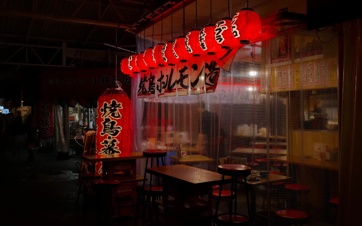Vibrant red lanterns illuminate a street bar in Osaka, Japan at night.